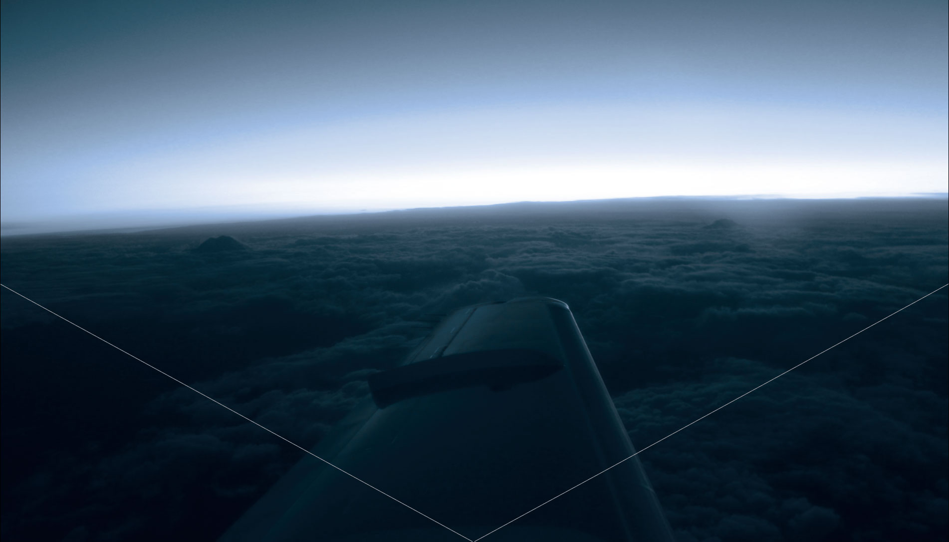 View of the wing of an aircraft flying over a cloudscape.